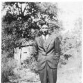 Charlie Floyd Bailiff standing in front of his grandfathers home, James Monroe Bailiff